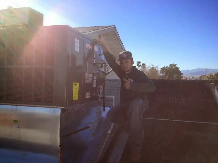 HVAC technician performing Boiler Repair on a rooftop unit in Woodcrest